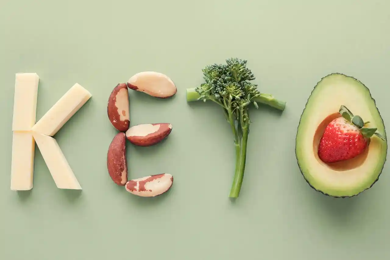 qt=q_30 (3) Various foods arranged to spell "KETO" on a green background: cheese as "K," nuts as "E," broccoli as "T," and half an avocado with a strawberry as "O.