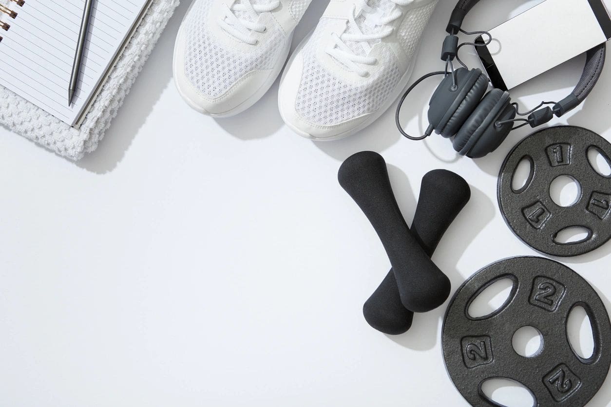 Fitness gear with shoes, weights, and headphones.