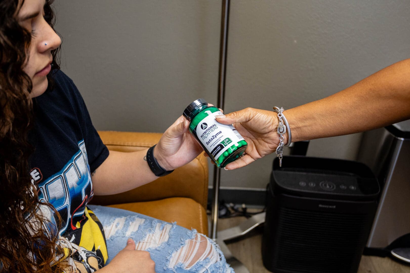 Person receiving a bottle of dietary supplements.