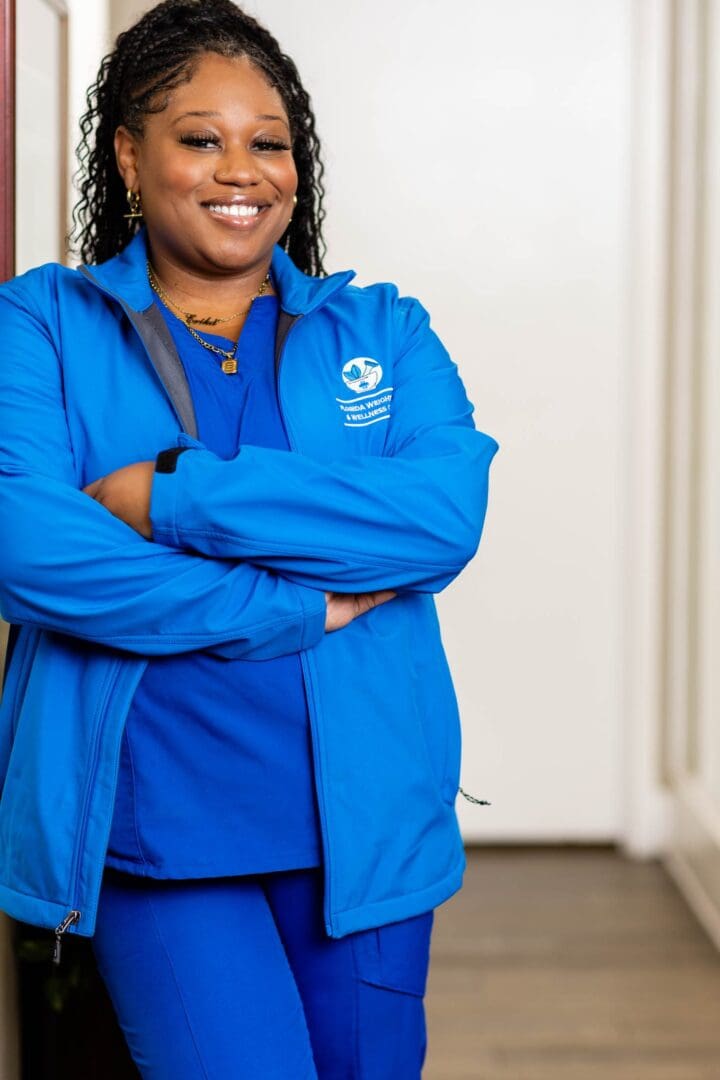 Smiling woman in blue medical uniform.