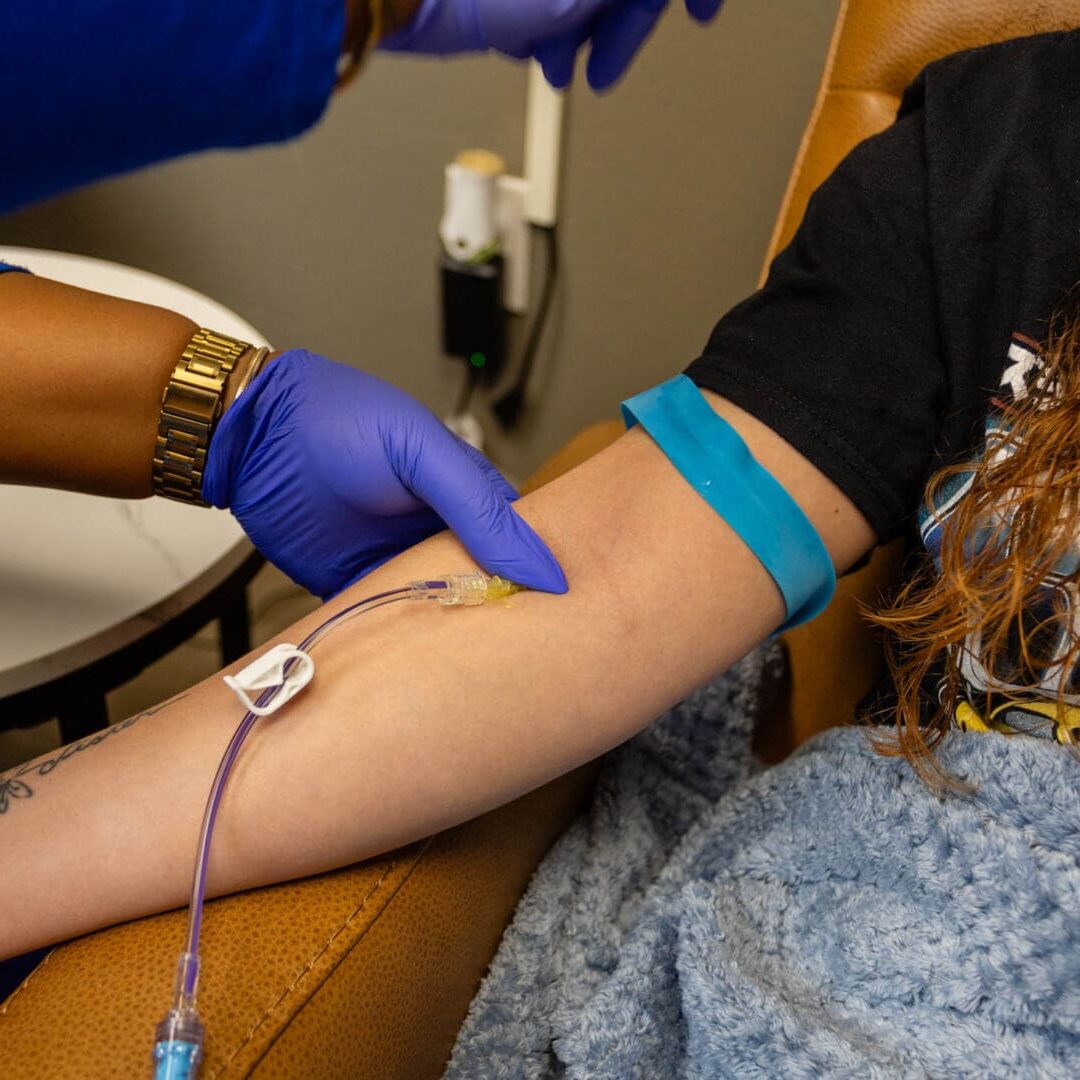 Nurse administering IV treatment to patient.