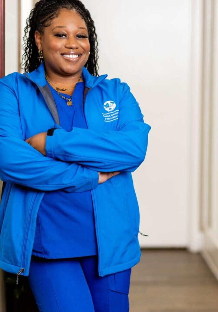 Smiling woman in blue medical uniform.
