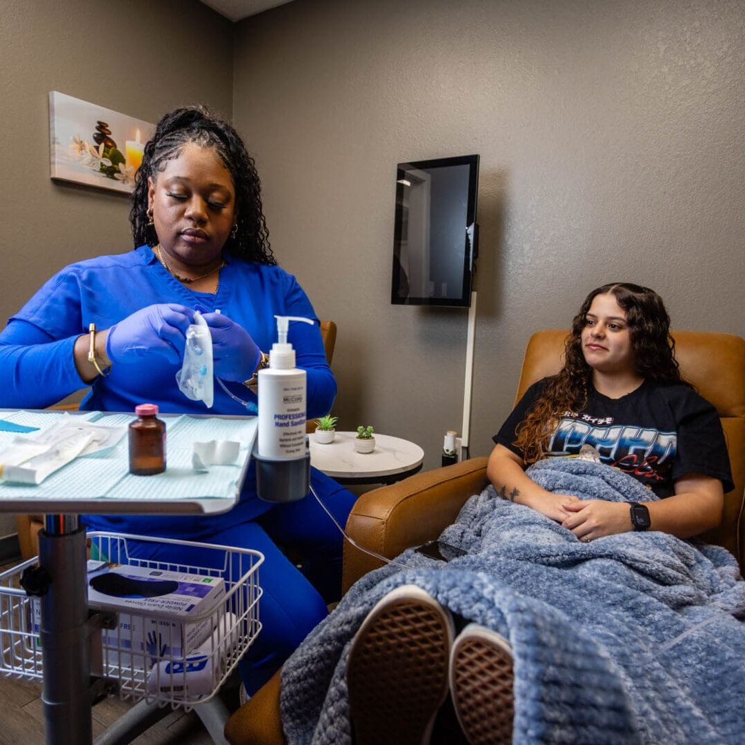 Nurse preparing IV treatment for patient.
