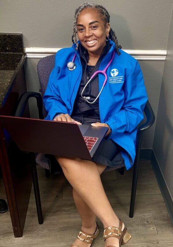 Smiling woman with laptop and stethoscope.